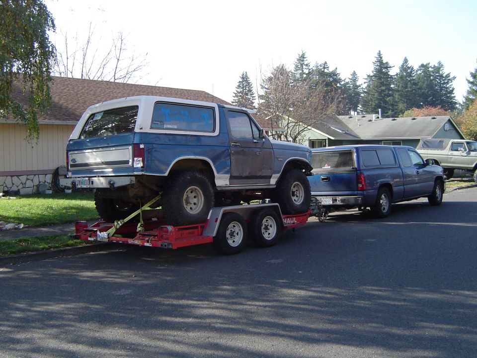 Blue and white SUV on trailer, 1980s body style