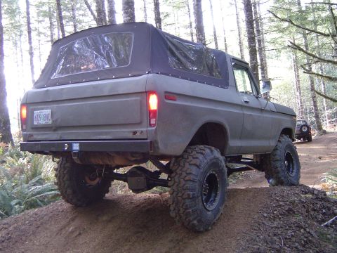 1978 Ford Bronco - Modified 1978 Ford Bronco navigating an off-road trail with a second vehicle visible ahead.