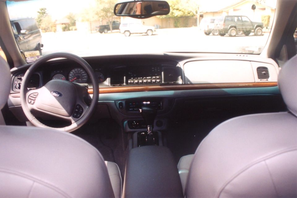 Interior dashboard of a Ford Crown Victoria with woodgrain trim and column shift