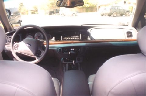2002 Ford Crown Victoria - The interior of a 2002 Ford Crown Victoria, viewed from the back seat, reveals the dashboard and steering wheel.