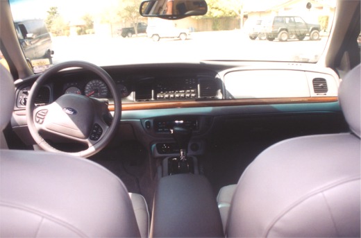 Interior of a 2002 Ford Crown Victoria showing the dashboard, steering wheel, and seats