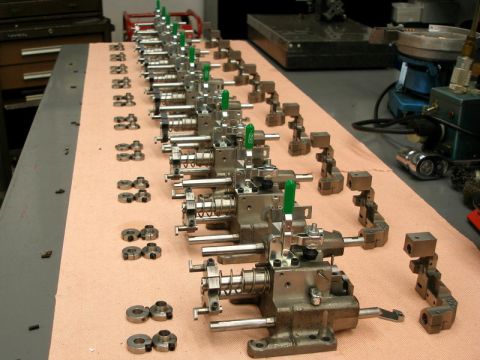 1996 Ford Bronco - A collection of identical machined components are neatly arranged on a workbench.