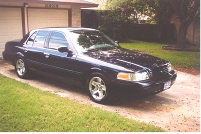 2002 Ford Crown Victoria - Dark blue 2002 Ford Crown Victoria parked in front of a garage.