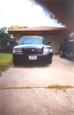 2002 Ford Crown Victoria - Front view of a black 2002 Ford Crown Victoria parked in a driveway.