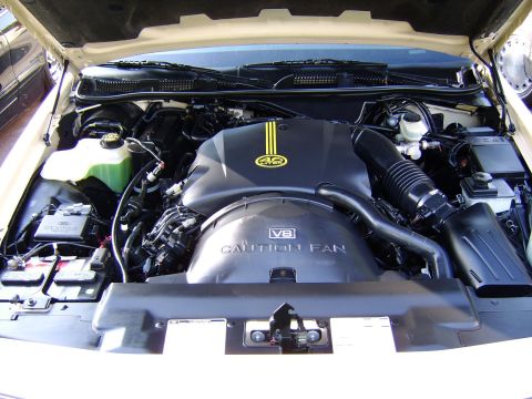 1996 Mercury Grand Marquis - The engine bay of a car is shown with the hood up, revealing the V8 engine and various components.