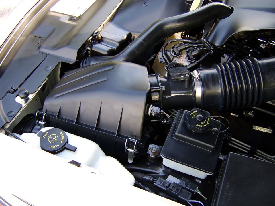 Engine bay with black air box, intake tube, washer fluid and power steering reservoir caps