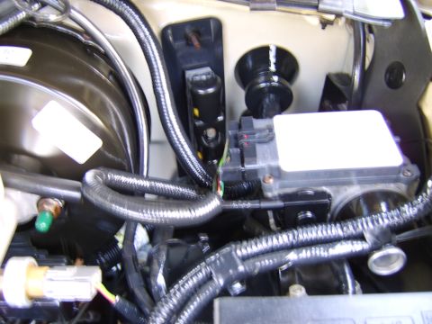 1996 Mercury Grand Marquis - This image shows various engine bay components, including wiring harnesses and an electronic control module.
