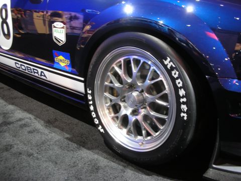 1998 Ford Crown Victoria - Close-up of a polished mesh wheel and Hoosier racing slick on the blue Cobra-striped Mustang race car.