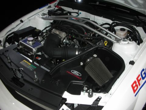 1998 Ford Crown Victoria - Engine bay of a white race car fitted with a Ford Racing cold-air intake and a polished strut tower brace.