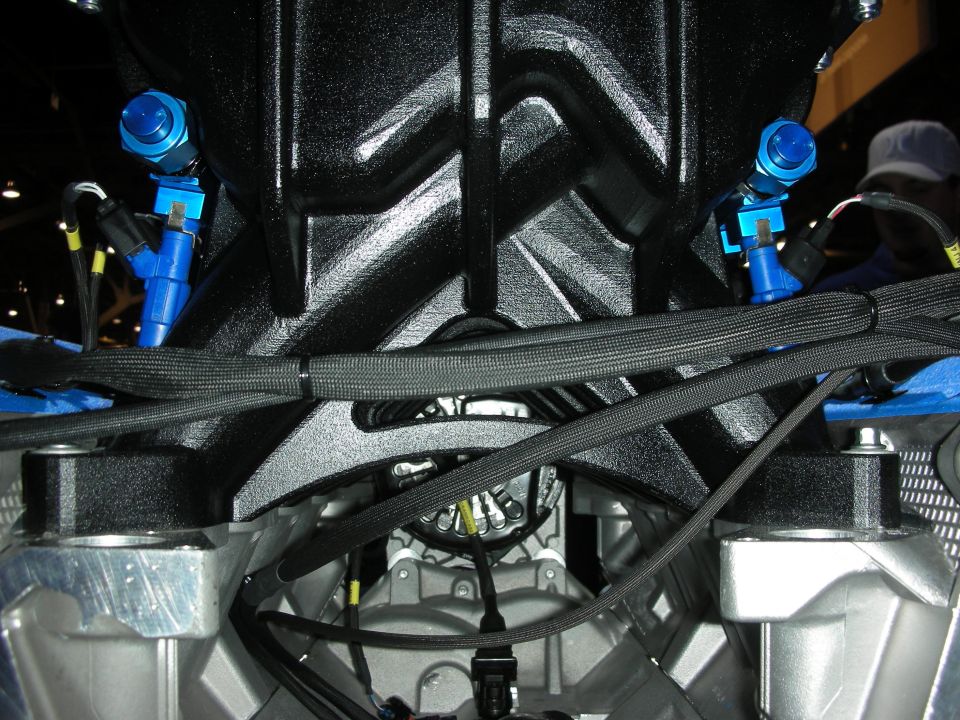 Close-up of black intake manifold with blue fuel fittings on a V8 engine