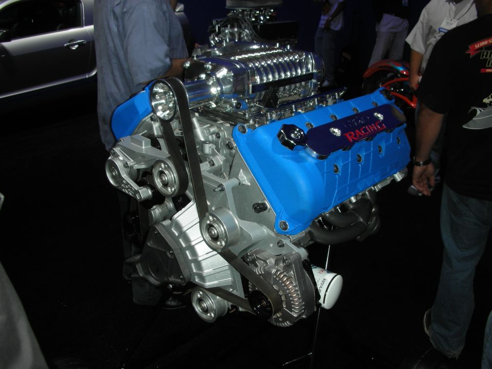 Blue supercharged Ford Racing V8 engine with polished blower on stand
