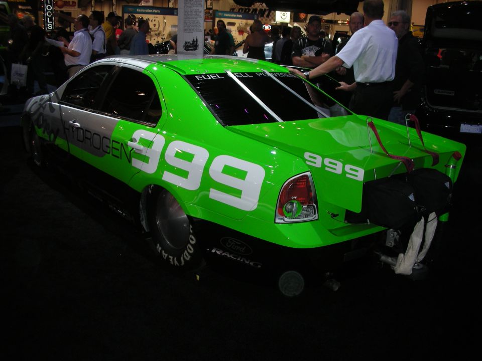 Green and silver Ford race car numbered 999 with Hydrogen and Goodyear markings