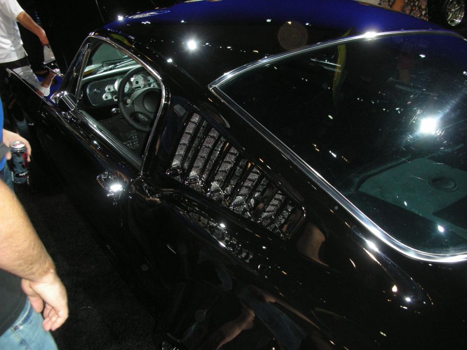 Glossy black fastback car side window with louvers and chrome trim