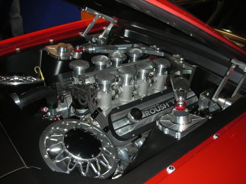Polished Roush V8 race engine with individual throttle stacks in a red car