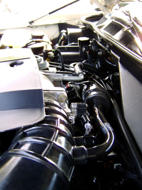 1996 Mercury Grand Marquis - Close-up view of a car's engine bay, focusing on the air intake system and associated components.