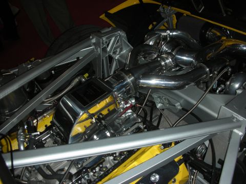 Mid-mounted polished twin-turbo engine in a yellow tube-frame race car chassis