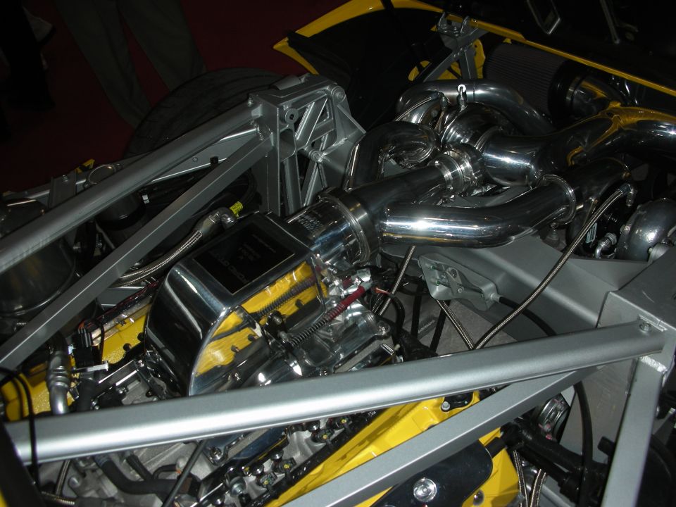 Mid-mounted polished twin-turbo engine in a yellow tube-frame race car chassis