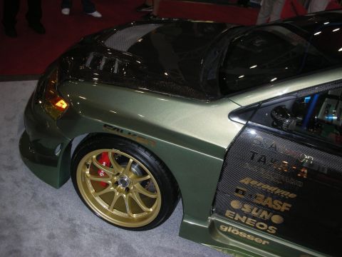 Rear quarter of green show car with gold wheels and carbon roof
