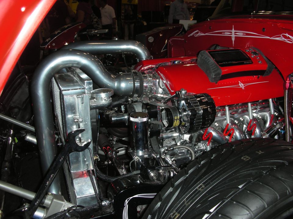 Chromed and polished V8 engine in red hot rod engine bay