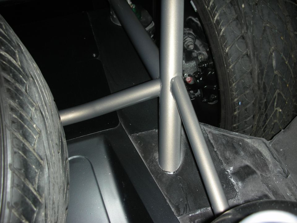 Tube-frame chassis crossmember between two tires in custom car underbody