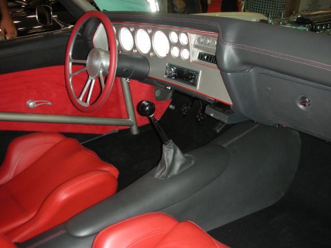 Custom dashboard with round gauges, red seats, and floor shifter
