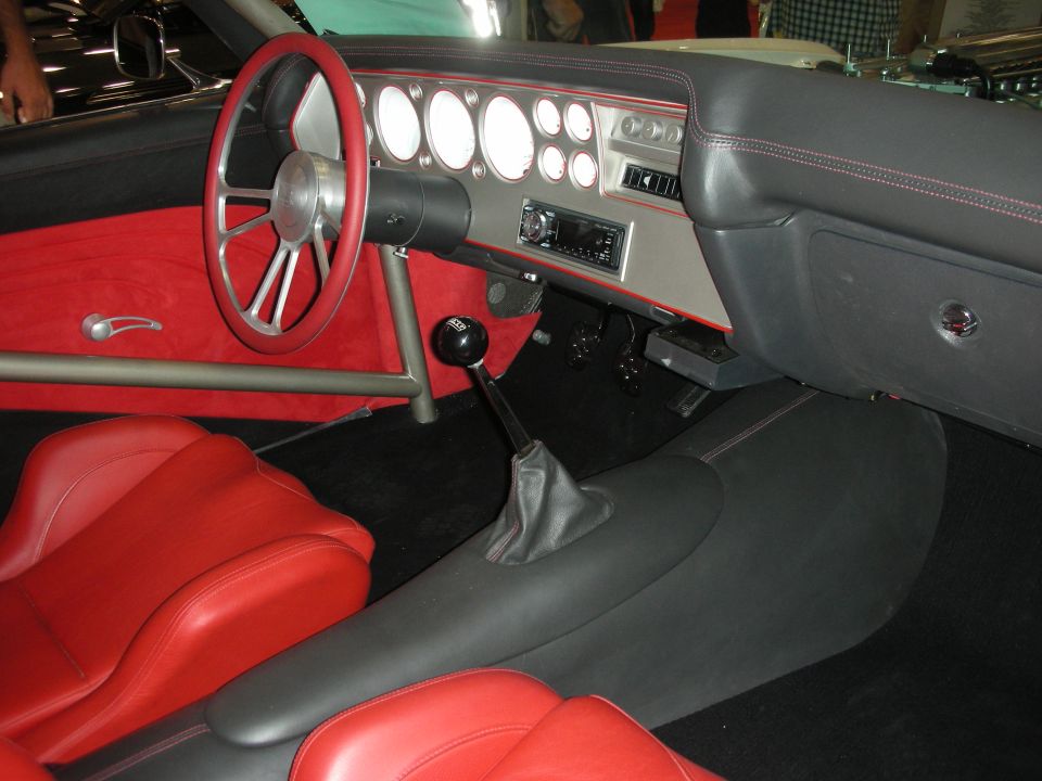 Custom dashboard with round gauges, red seats, and floor shifter
