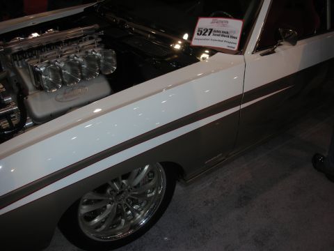 1998 Ford Crown Victoria - lowered side of a white custom car with a bronze stripe and chrome wheel, beside a placard reading 527 small block Chevy.