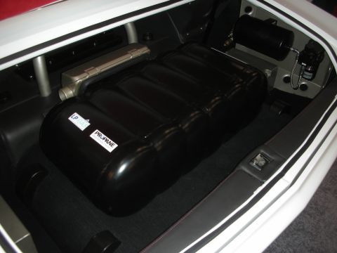 1998 Ford Crown Victoria - black LP propane tank mounted in the carpeted trunk of a white custom car, with plumbing and a small valve box.
