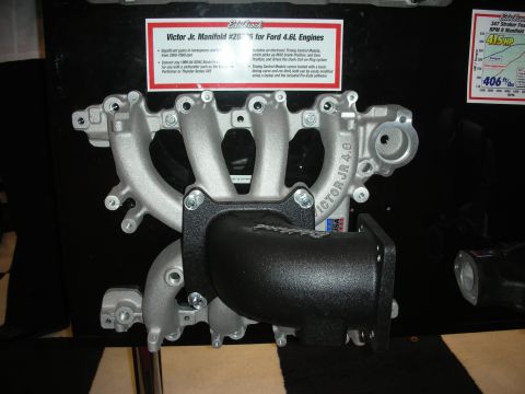 1998 Ford Crown Victoria - Edelbrock Victor Jr aluminum intake manifold for Ford 4.6L engines on display with a descriptive placard behind it.