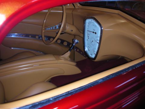 1998 Ford Crown Victoria - tan leather interior of a red custom car, showing a drilled banjo steering wheel, shifter and oval white gauge cluster.