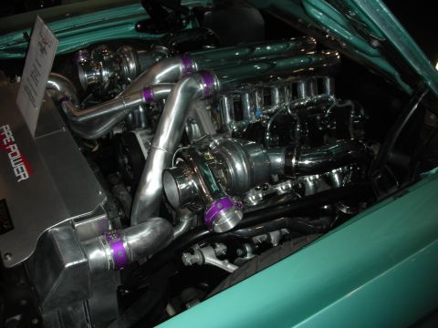 1998 Ford Crown Victoria - Polished twin-turbo engine bay using purple silicone-band couplers and chrome piping installed in a teal-painted car.