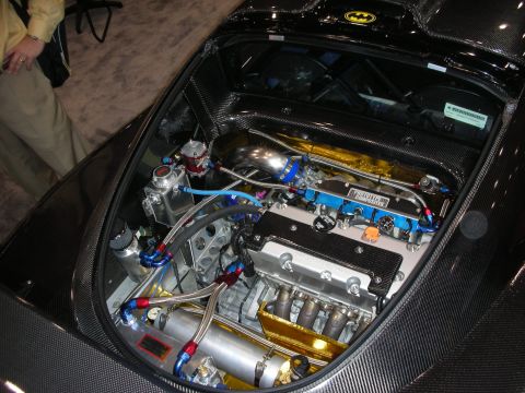 1998 Ford Crown Victoria - Carbon-fiber mid-engine bay with gold-anodized tanks, blue AN fittings and braided lines under a hatch bearing a Batman decal.