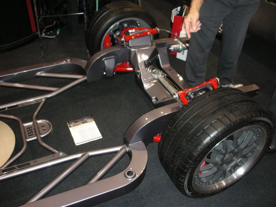 Front view of a fabricated tube chassis with red suspension arms and a wheel
