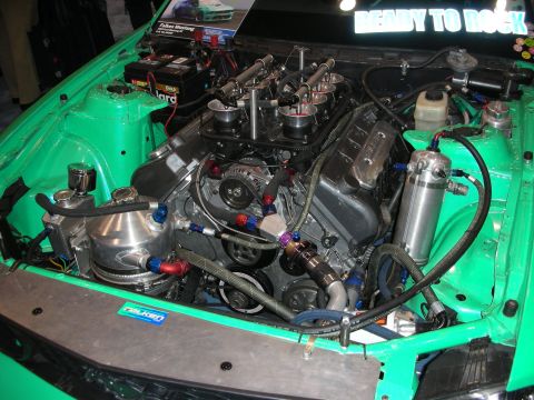 1998 Ford Crown Victoria - green-painted engine bay houses a built V8 with stack-style individual throttle bodies, braided lines and a polished accessory drive.