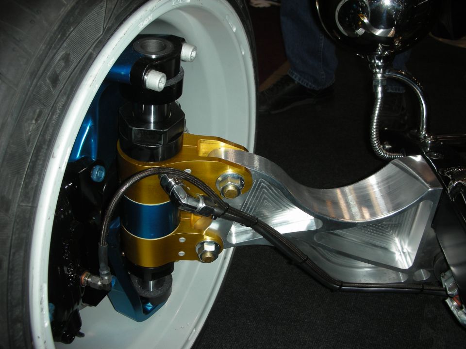 Polished billet suspension arm with gold and blue coilover on white wheel