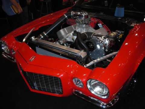 1998 Ford Crown Victoria - red second-generation Camaro displays its open engine bay with a supercharged V8, chrome carburetor and black intake piping.