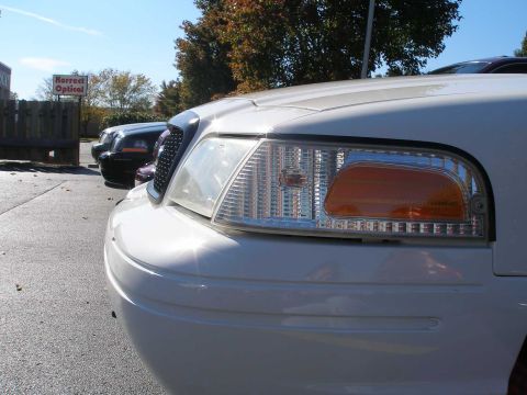 2001 Ford Crown Victoria - Front corner of a white 2001 Ford Crown Victoria, parked outdoors with another vehicle nearby.