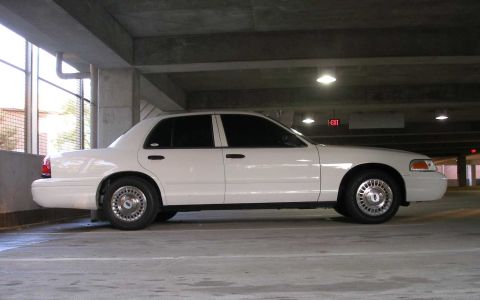 2001 Ford Crown Victoria - A white 2001 Ford Crown Victoria is parked in a multi-level concrete garage.