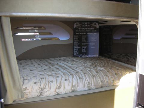 1998 Ford Crown Victoria - made bed inside a custom coach with a black dedication plaque from a coach builder mounted on the wall above.