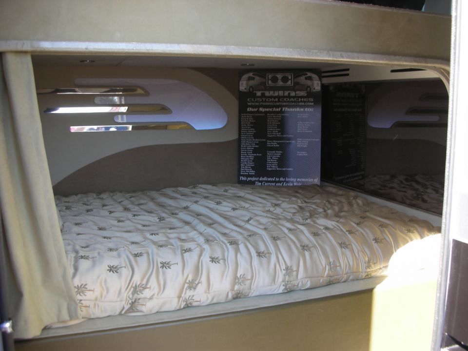 Built-in coach bed with a memorial dedication sign mounted above it