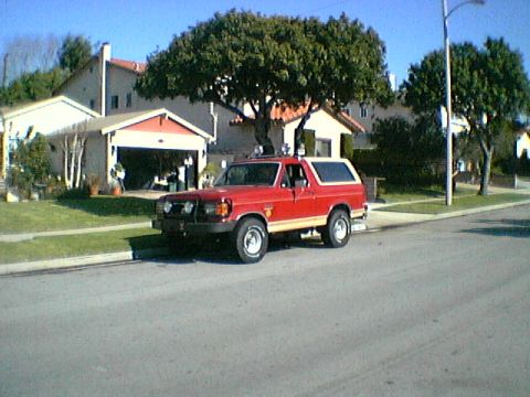 1989 Ford Bronco - Red 1989 Ford Bronco parked on a residential street.