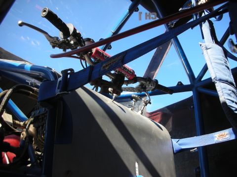 1998 Ford Crown Victoria - Interior of a blue tube-frame off-road buggy showing a hand-brake lever, steering linkage, and harness anchor points under open sky.