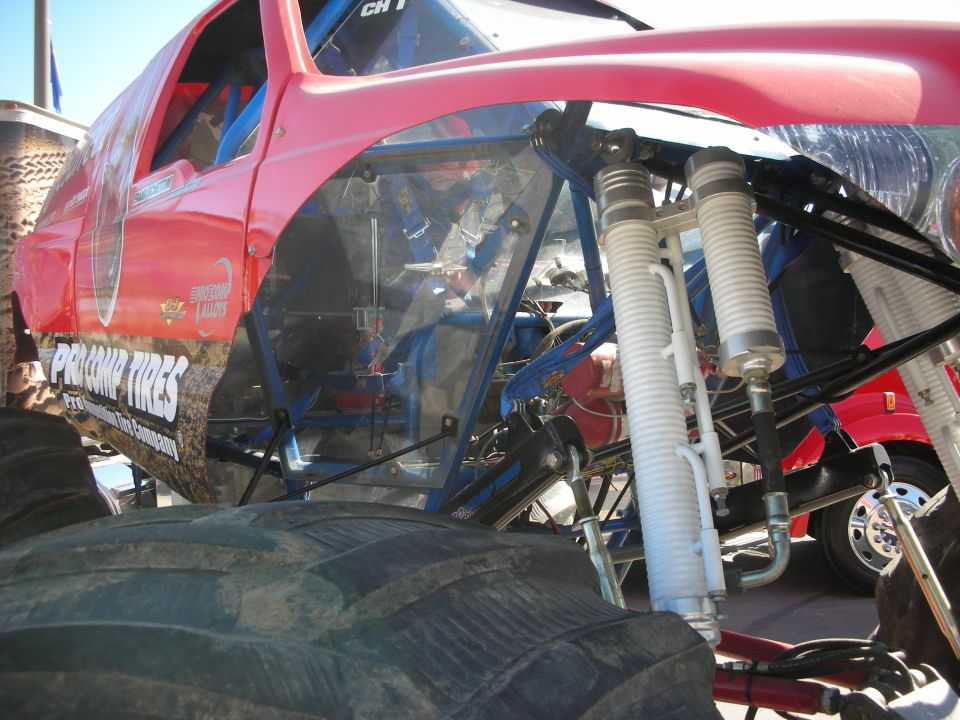 Red-bodied tube-chassis trophy truck with exposed coilover shocks