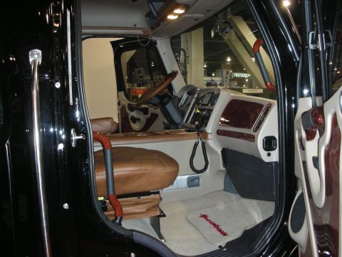 1998 Ford Crown Victoria - Two-tone tan and black King Ranch-style leather truck interior with wood trim and an embroidered floor mat, seen through the open door.