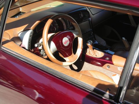 1998 Ford Crown Victoria - Custom car interior viewed through the side window, showing tan and maroon leather, a billet steering wheel and a chrome shifter.