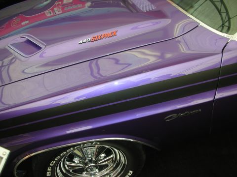 1998 Ford Crown Victoria - Detail of a purple muscle car fender with a '440 Six Pack' hood callout, Challenger script and a BFGoodrich tire on a chrome wheel.