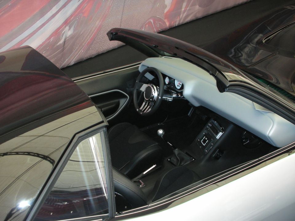 Open convertible interior with gray dash, billet steering wheel and black seats