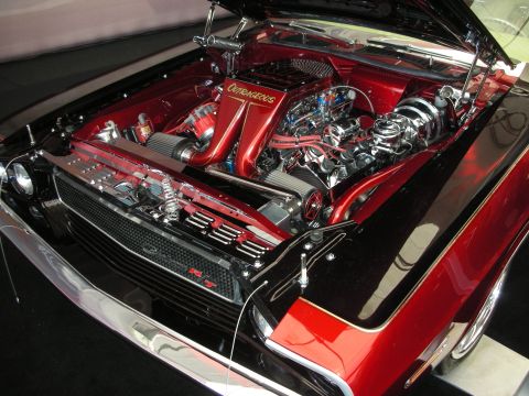 1998 Ford Crown Victoria - highly detailed red-and-black custom engine bay marked 'Outrageous', featuring chrome accents and a polished radiator core support.