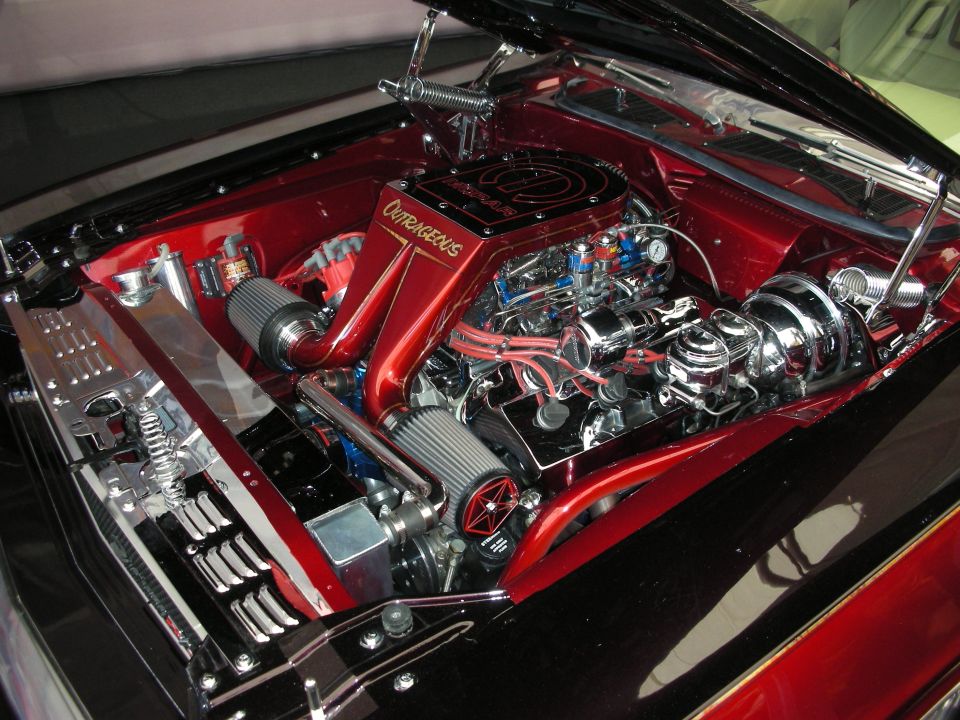 Custom V8 engine bay of a show car with red firewall and chrome dress-up