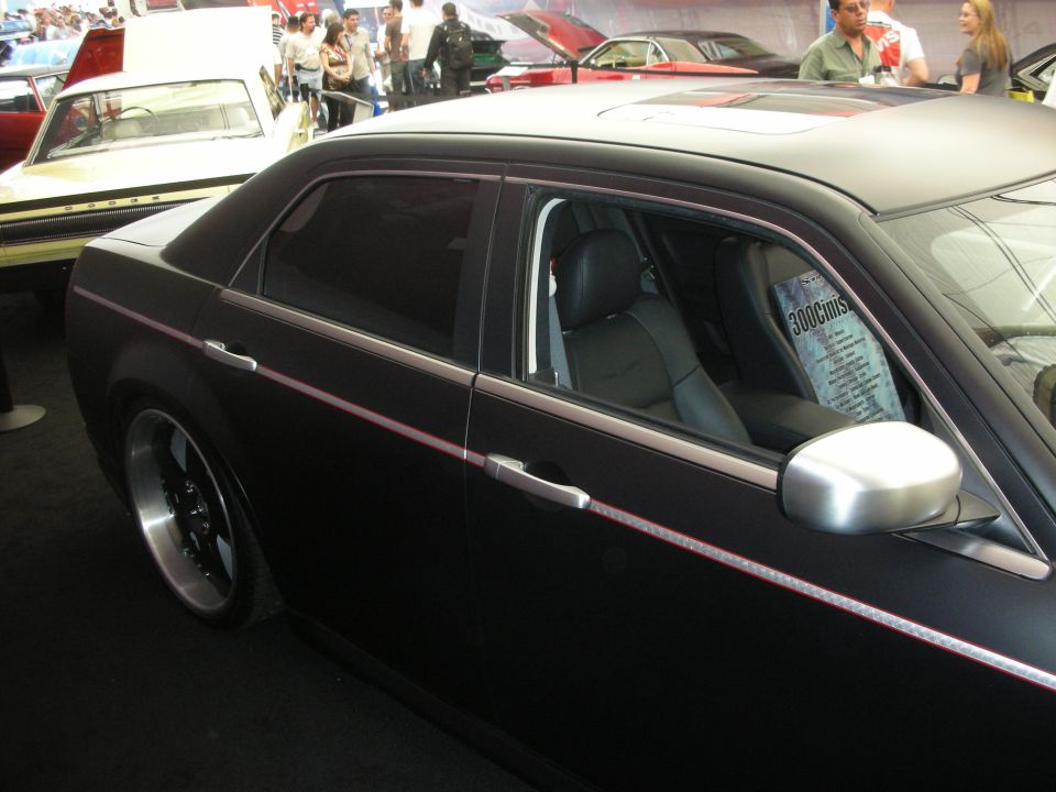 Side window and interior of a matte-black Chrysler 300 at an indoor show